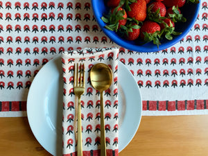 SUNDAY/MONDAY's POPPY table linens featuring a summery floral inspired pattern. Red and white cloth napkins and a table runner. 